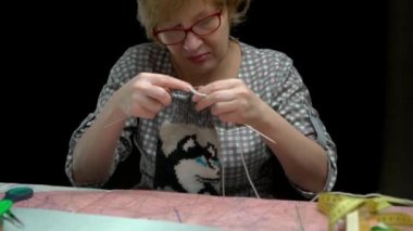 koyu bir arka planda ev hanımı çorap dikiş