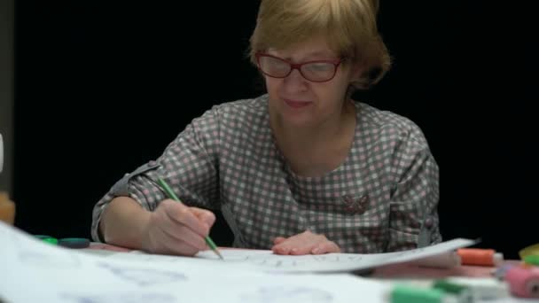Vrouwelijke ontwerper tekenen kleren schets op papier — Stockvideo