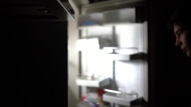 Attraktiv tonåring dricker sval mjölk från kylskåpet på natten — Stockvideo