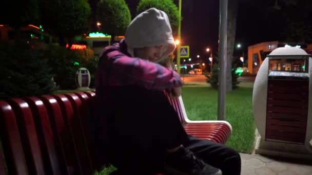 Tiro volante di giovane seduto sulla panchina, perso in città — Video Stock