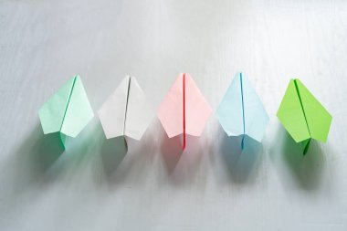 Renkli kağıt uçaklar, masanın üzerinde el yapımı origami.