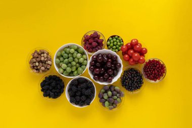 Taze kiraz, ahududu, çilek, böğürtlen, Bektaşi üzümü, dut ve üzüm diyeti içeren kaselerin üst görüntüsü