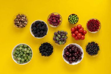 Taze kiraz, ahududu, çilek, böğürtlen, Bektaşi üzümü, dut ve üzüm diyeti içeren kaselerin üst görüntüsü