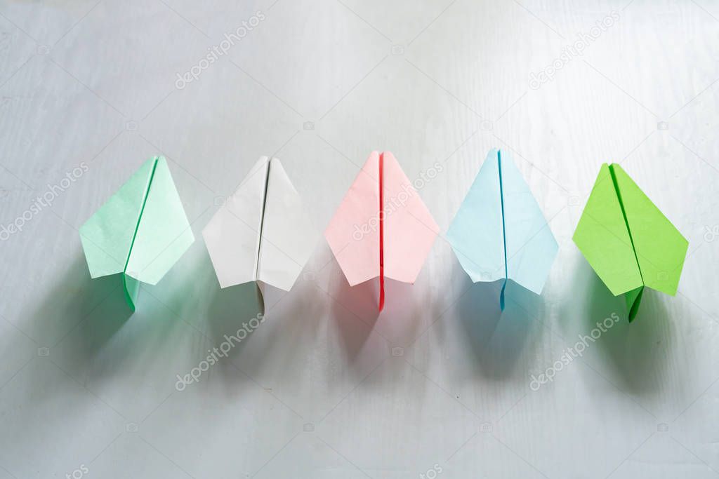 row of some color paper planes, handmade origami on the table
