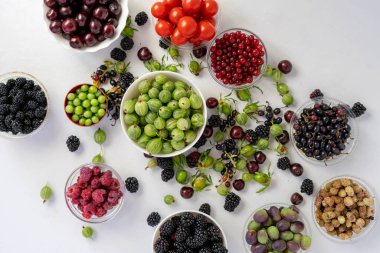 Taze kiraz, ahududu, çilek, böğürtlen, Bektaşi üzümü, dut ve üzüm diyeti içeren kaselerin üst görüntüsü