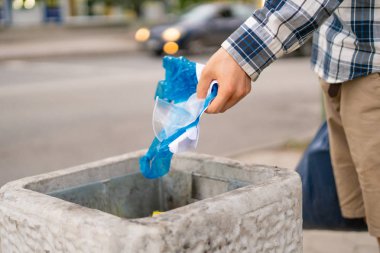 Şehir sokaklarında çöp kutusuna kağıt ve plastik çöp atmak.