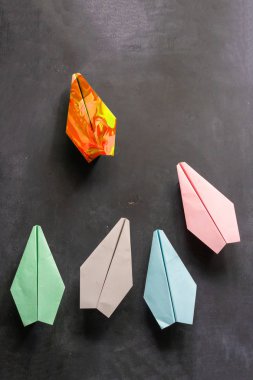 Düzenli uçakları olan eşsiz bir kağıt uçak. Masalarda liderlik kavramı.