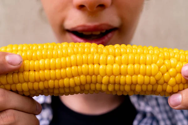 Persona da vicino mangiare e mordere cotto mais caldo preparato, concetti di street food — Foto Stock