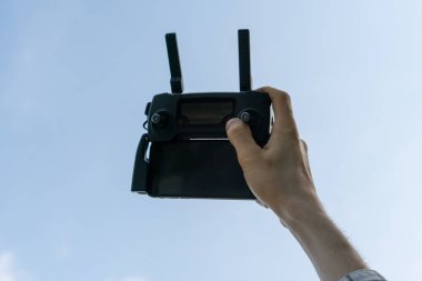 joystick ve antenlerle uzaktan kumandalı bir kablosuz cihaz tutan kişi