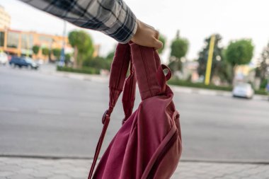 Kırmızı sırt çantalı bir el gezintide, yolculuğa çıkıyor.