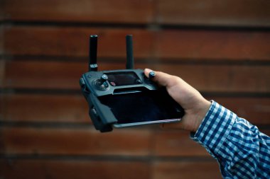 joystick ve antenlerle uzaktan kumandalı bir kablosuz cihaz tutan kişi