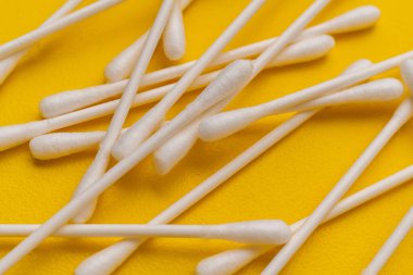 Sarı yüzeyde pamuklu kulak çubukları, makro görüş.