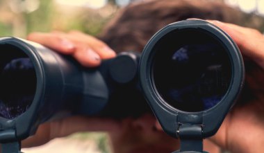 Makro lens görüşü, elinde dürbünle turisti kapatarak yolu arıyor