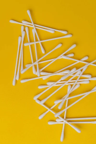 Bunch of cotton ear sticks swabs on yellow surface, macro views — Stock Photo, Image