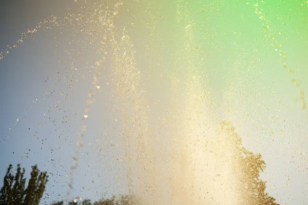 Абстрактные брызги воды из фонтана в городском общественном парке против неба — стоковое фото