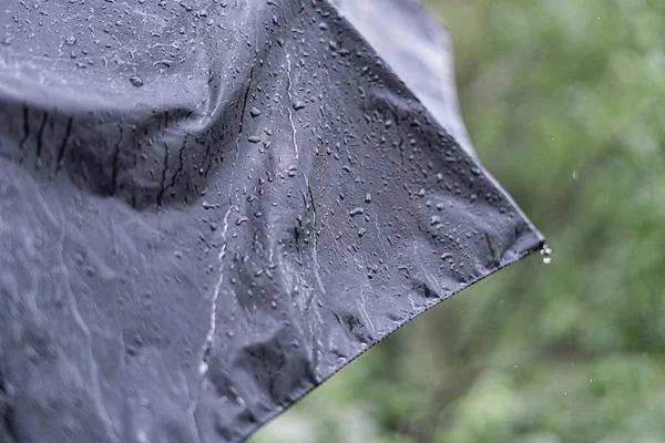 Vicino gocce di pioggia sulla superficie dell'ombrello durante la pioggia, macro shot s — Foto Stock