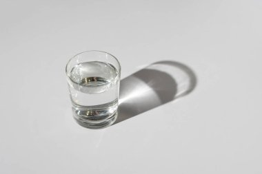 Masanın üzerinde sert bir gölge olan basit ve durgun bir su.