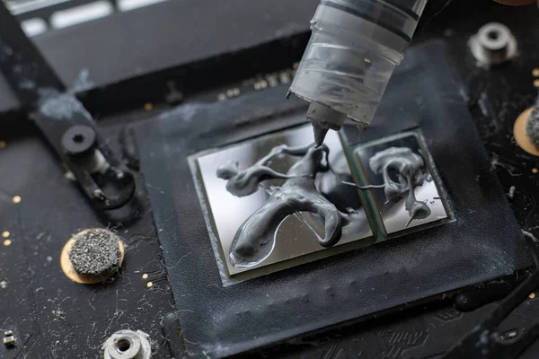 A applying the thermal grease to the gpu chip for better heat management, macro view — Stock Photo, Image