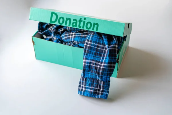 Caixa de papelão com roupas no interior, uma doação para crianças de países pobres — Fotografia de Stock