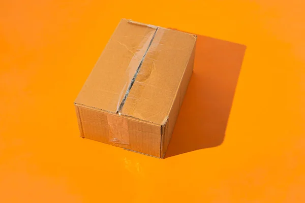 Simple box delivery on color surface table, sending mail with things — Stock Photo, Image
