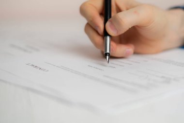 Kişi elini kalem tutarak evrak sözleşmesini imzaladı, anlaşma başarısı kavramı