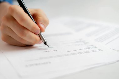 Kişi elini kalem tutarak evrak sözleşmesini imzaladı, anlaşma başarısı kavramı