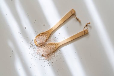 Masada deniz tuzu olan ahşap kaşık, üst manzara izole.