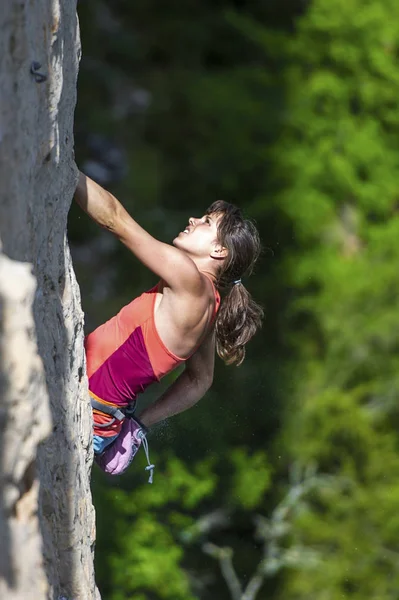 フランスのミヨーの街の上の石灰岩登りを要求中にチョーク バッグに手を差し伸べる女性登山家 — ストック写真