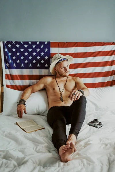 Jovem Sem Camisa Homem Chapéu Deitado Cama Com Bandeira Americana — Fotografia de Stock