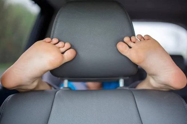 Uma Criança Banco Trás Carro Envolve Seus Pés Volta Banco — Fotografia de Stock