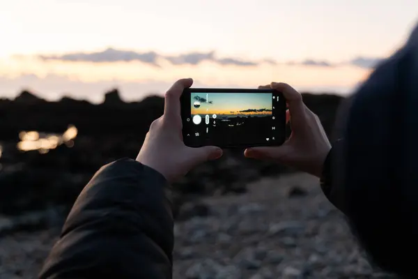 Деталь Рук Держащих Смартфон Фотографирующих Закат Над Пляжем — стоковое фото