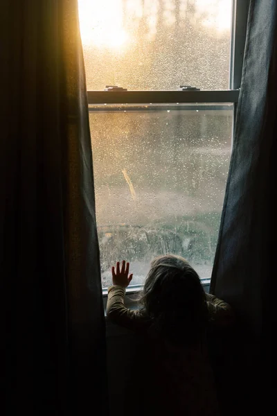 Kislány Nézi Naplementét Ablakon Keresztül — Stock Fotó