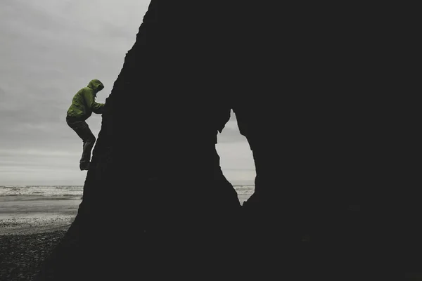 Silueta Záběr Mladého Muže Lezení Skalní Formaci Blízkosti Oceánu — Stock fotografie