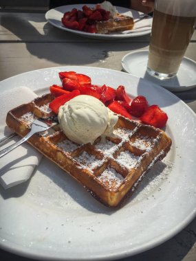 Çilek ile waffle ve Latte Macchiato ile hizmet bir plaka üzerinde dondurma