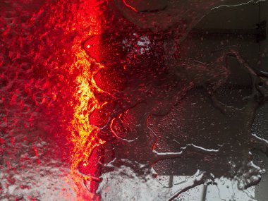 Bir kırmızı ışık şerit ile bir arabanın içinden bir ön cam su çalışan