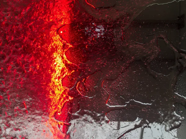 Bir kırmızı ışık şerit ile bir arabanın içinden bir ön cam su çalışan