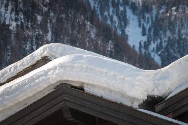 Bol karlı güneşli bir öğleden sonra konut evler çatı üzerinde katmanlar halinde