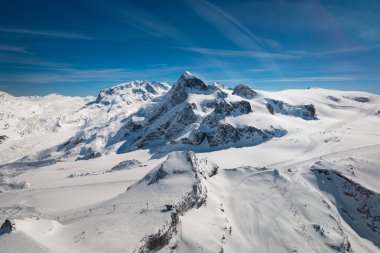 Zermatt ve Breuil-Cervinia Breithorn, Klein Matterhorn dağ (ön planda) ve Monte Rosa ile kayak bölgesinin karla kaplı manzara havadan görünümü