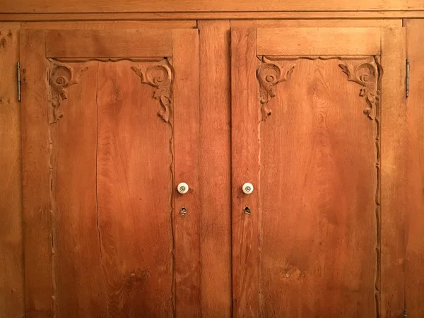 Front of wooden cabinet doors with keys and knobs