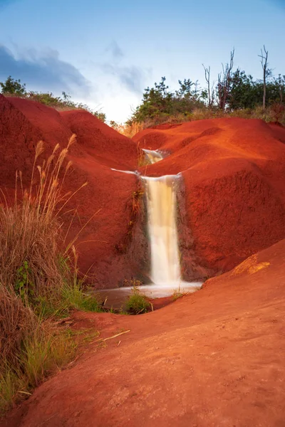 Small waterfall on red soil, Kauai, Hawaii, USA