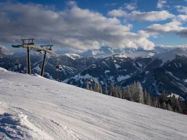 Vorderglemm, Avusturya 29 Ocak 2019: Saalbach-Hinterglemm bölgesinde mavi ve bulutlu gökyüzüne karşı Schnleiten teleferik kaldırışı.