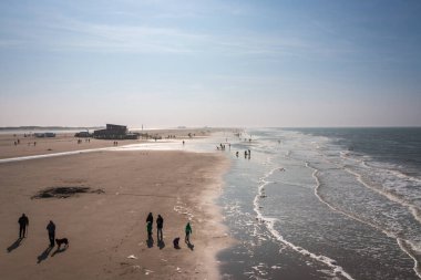 Sankt Peter-Ording, Almanya 'da sonbaharda alçak gelgit sırasında gökyüzüne karşı insanların olduğu kuzey deniz sahili manzarası