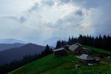 Karpatlar 'daki ahşap kulübe Bulutlu bir gökyüzünün altındaki vadide