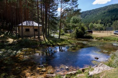 Source of the arlanza river with refuge and reflection in the river next to Quintanar de la Sierra in Burgos, Spain clipart
