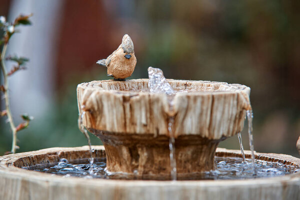 figurine of a bird at a decorative summer fountain, water