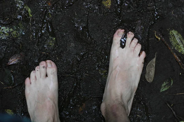 Person Die Durch Den Schlamm Geht Während Sie Einen Wasserfall — Stockfoto