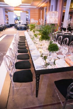 Palmiye yaprağı düğün masası. Mumlar, peçeteler ve aynalı masalar..