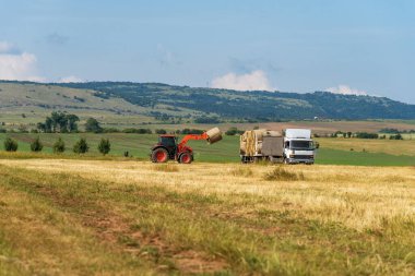 Hay Bale ile çalışan traktör.