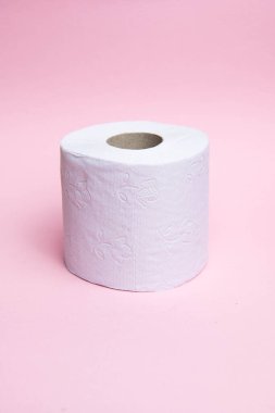 Pembe arka planda bir rulo tuvalet kağıdı.
