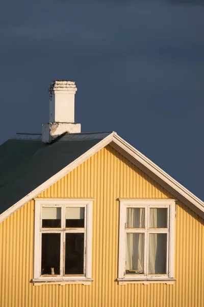 Yellow Corrugated Iron Scandinavian House Against Stormy Blue Grey Sky